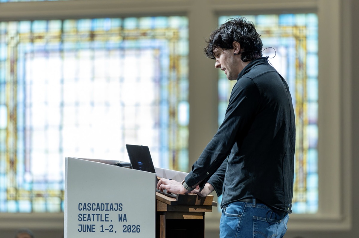 A speaker presenting at the CascadiaJS 2026 podium